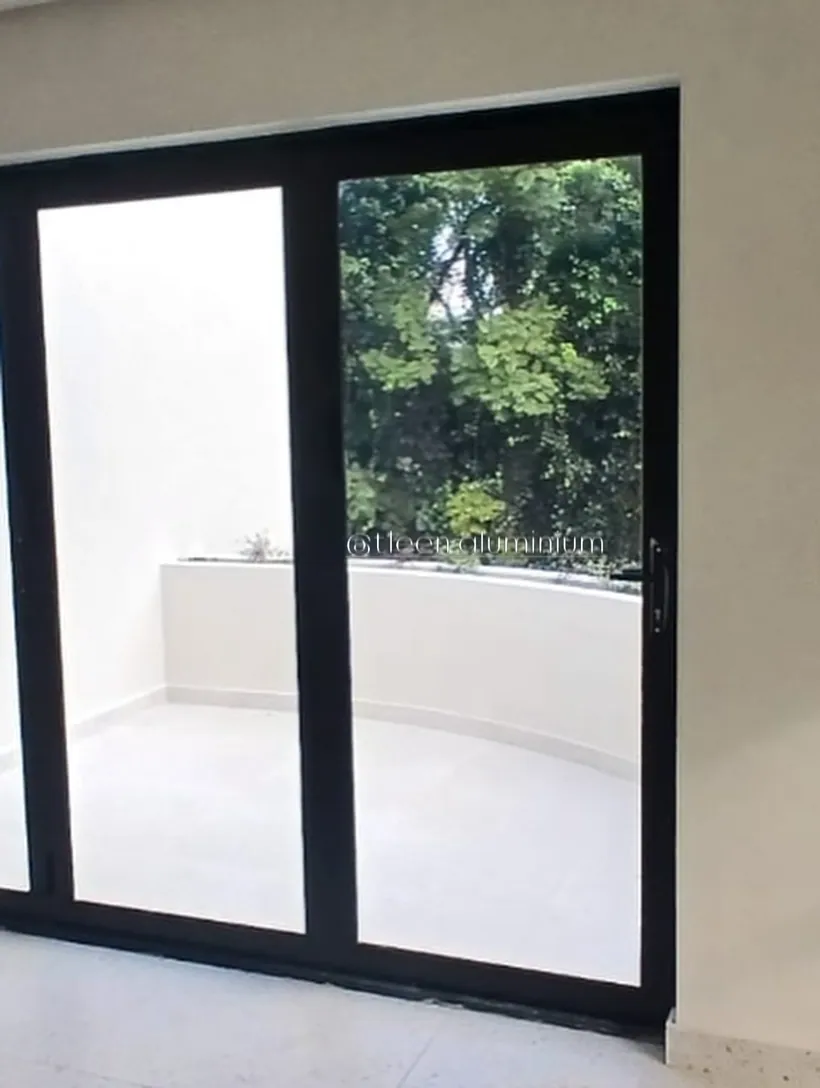 Charcoal aluminium door with fixed pane leading to a white balcony