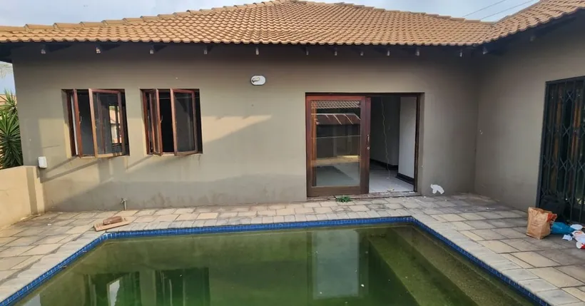 Full house elevation onto a pool, all openings in wood-look aluminium