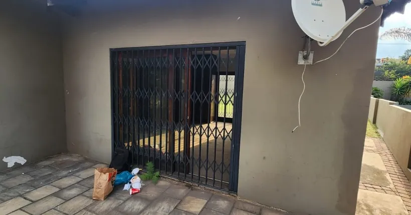 Charcoal trellis gate secured across a wide patio opening