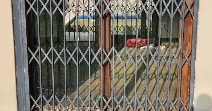 Trellis security gate fitted over a wood-look framed window